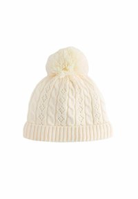 Crème gebreide beanie met een pompon bovenop, voorzien van een kabelbreipatroon en een geribbelde manchette, gemaakt van zachte, gestructureerde garen.
