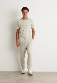 BOSS HADIKO - Spodnji deli trenirk - light beige
