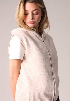 Gilet en tricot beige avec capuche, fermeture éclair et ourlet côtelé. Conception sans manches avec une texture douce, présentant un motif subtil.