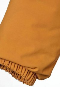 Orange tygsleeve med elastisk mudd, med en slät och något texturerad yta. Inga synliga mönster eller hårdvarudetaljer.