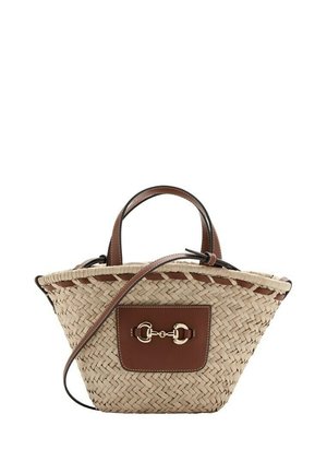 Sac à main en paille tressée avec poignées en cuir marron, patch avant et détail mors en argent, avec une longue bandoulière en cuir réglable.