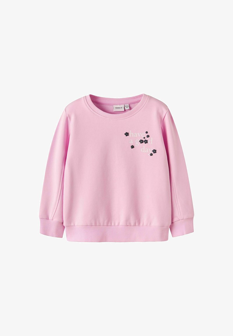 Jasnoróżowy sweter z długim rękawem, z prążkowanymi mankietami i dołem, z nadrukowanym napisem "miłego dnia" oraz małymi czarnymi akcentami w postaci kwiatów.