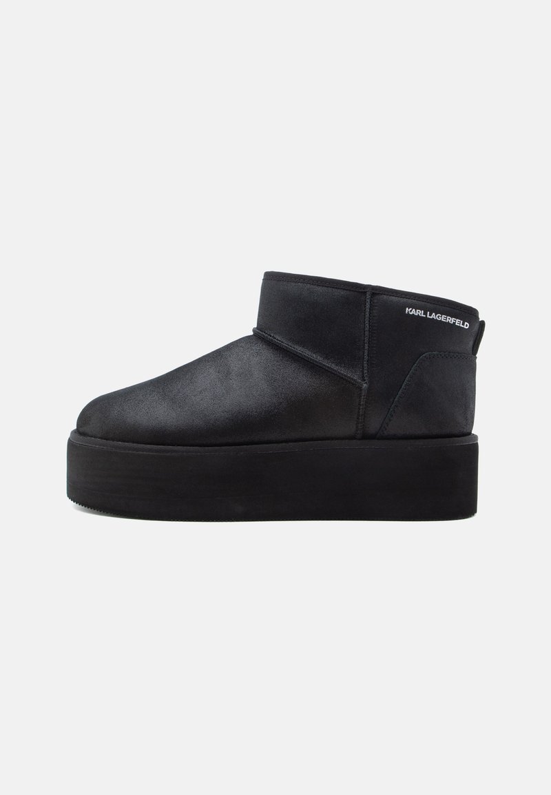Must musta ankle boot ümarate varvaste ja lamedate platvormisalustega. Omab minimalistlikku disaini ja külgmist logo detaili.