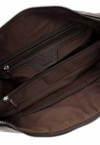 Intérieur d'un sac en cuir marron avec une doublure en tissu lisse et plusieurs compartiments zippés. Comprend un tirette de zip texturée et un détail de logo.
