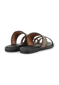 Sandalias planas negras con diseño superior trenzado en beige y negro. Presentan secciones recortadas y acentos cosidos a lo largo de los bordes.