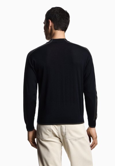 Maglione nero lavorato a maglia con scollatura rotonda e maniche lunghe, con due strisce verticali lungo le spalle. Texture liscia.