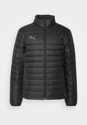 Veste noire rembourrée avec un col haut, fermeture éclair intégrale, coutures horizontales et un logo réfléchissant. Texturé léger, surface lisse et design ajusté.