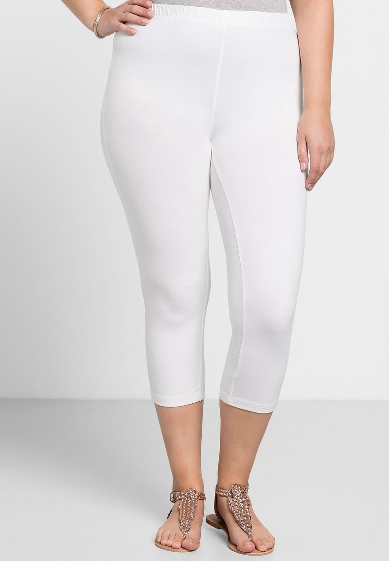 Leggings capri blancs fabriqués en tissu extensible, dotés d'une taille élastique, d'une texture lisse et d'un design ajusté qui se termine sous le mollet.