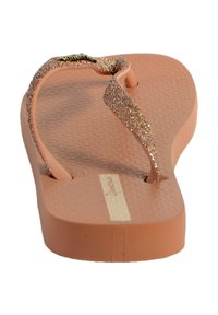 Tongs roses avec semelle en caoutchouc texturée, brides glitter en or rose, et une semelle intérieure lisse. Dispose d'un petit logo sur la semelle intérieure.