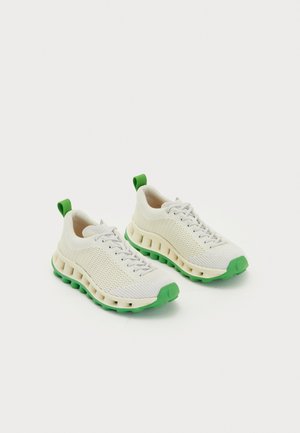 Lightweight white sneakers with green accents and a textured mesh upper. Features curved sole and pull tabs at the heel.