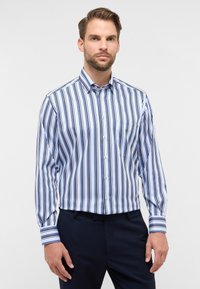 Camicia button-up con righe verticali in tonalità di blu e bianco. Caratterizzata da maniche lunghe, colletto e una tasca sul petto.