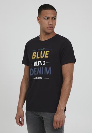 Black cotton t-shirt featuring bold text design in yellow, white, and blue that reads “VINTAGE BLUE BLEND DENIM ORIGINAL.” Short sleeves, crew neck.