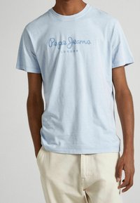 Světlomodré bavlněné tričko s krátkými rukávy a klasickým kulatým výstřihem. Na hrudi je logo "Pepe Jeans" v tmavě modré barvě.