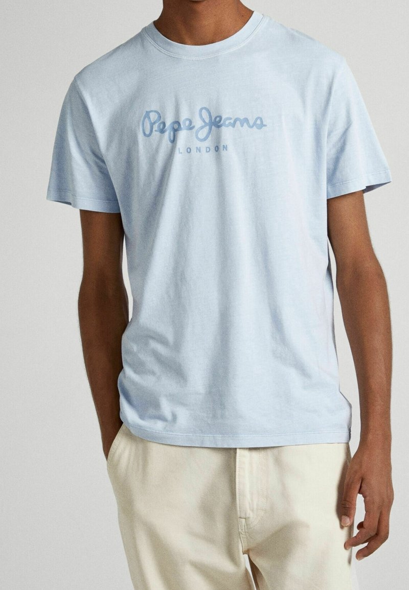 Světlomodré bavlněné tričko s krátkými rukávy a klasickým kulatým výstřihem. Na hrudi je logo "Pepe Jeans" v tmavě modré barvě.