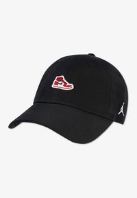 Μαύρο καπέλο μπέιζμπολ με κεντημένο μπροστινό λογότυπο κόκκινου και άσπρου αθλητικού παπουτσιού, με λευκό λογότυπο Jumpman στην πλευρά.