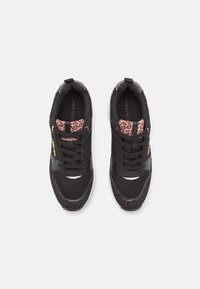 Black athletic shoes with mesh and leather materials, featuring leopard print accents on the ankle, round toe, and textured black laces.