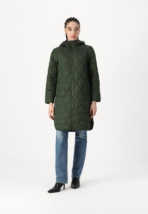 Quilted green coat with a hood and front zipper. Features a diamond pattern, three-quarter sleeves, and a relaxed fit, paired with blue jeans.