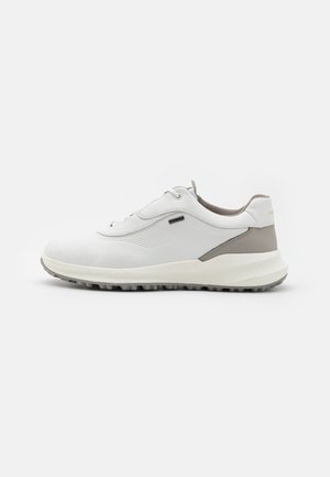 Zapatillas deportivas blancas con parte superior de cuero texturizado, detalles en gris claro, punta redonda, diseño de cordones y suela de goma con patrón.