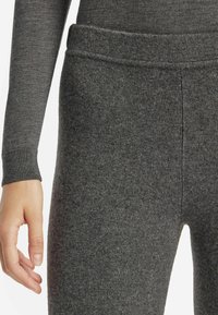 Leggings grigi, aderenti, realizzati in un morbido tessuto testurizzato con un alto elastico in vita. Comprendono un polsino alla caviglia per una vestibilità aderente.