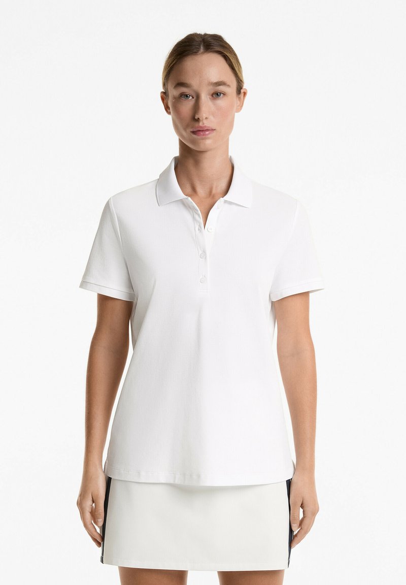 White polo shirt with a classic collar, three-button placket, short sleeves, and a straight hem. Made of soft, textured fabric.