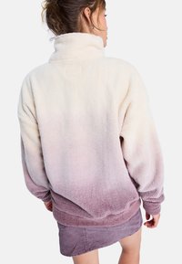 Fuzzy fleece pullover met een hoge kraag, met een verloop van cream naar mauve, geribde manchetten en zoom, met een relaxed fit.