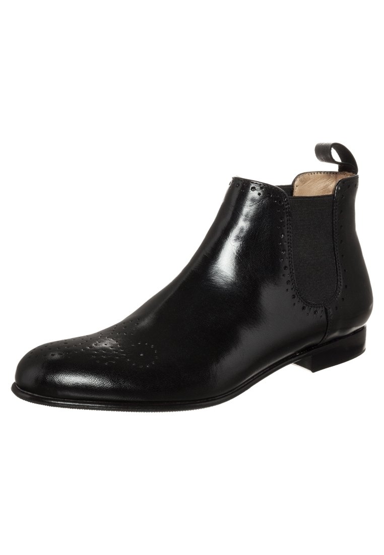 Botín Chelsea de cuero negro con detalles de brogue, paneles laterales elásticos, tirador en el tobillo y tacón bajo apilado.