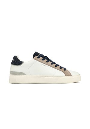 Zapatillas de cuero blanco con acentos de ante azul marino, detalles en ante gris y cordones azul marino. Presenta una suela de goma gruesa y un diseño minimalista.