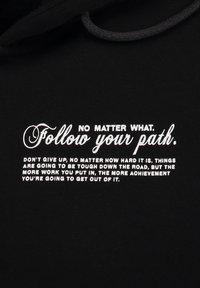 Sudadera negra con texto impreso en blanco. El diseño presenta una tipografía cursiva y en negrita, transmitiendo un mensaje inspirador. Textura suave, con capucha ajustable.