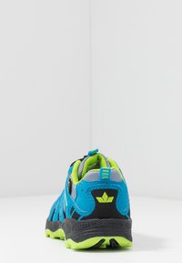 Zapatilla deportiva azul con detalles en negro y verde lima. Parte superior de tela y suela de goma. Cuenta con un collar acolchado y una lengüeta para facilitar su puesta.