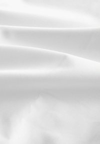 Weißer Stoff mit glatter Textur, der sanfte Falten und eine matte Oberfläche aufweist. Das Material wirkt leicht und sauber.