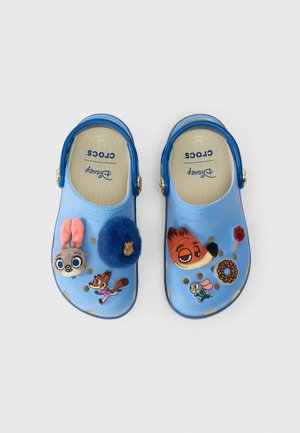 Des Crocs pour enfants bleu clair avec des personnages Disney, mettant en vedette Judy Hopps, Nick Wilde, un badge de police, un donut et un charme empreinte de patte.