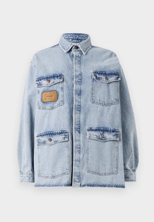 Világoskék, oversized farmerekabát, gallérral, elülső gombos záródással, négy zsebbel és egy barna bőr folttal a bal mellrészen.