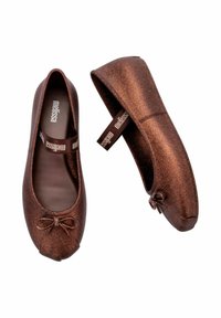 Brązowe brokatowe baletki z zaokrąglonym noskiem, z akcentem w postaci kokardy na czubku i elastycznym paskiem z logo na pięcie.