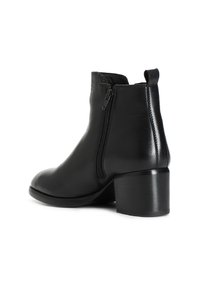 Stivale alla caviglia in pelle nera con zip laterale, punta rotonda e tacco a blocco robusto. Presenta un pull tab sul retro per una facile calzata.