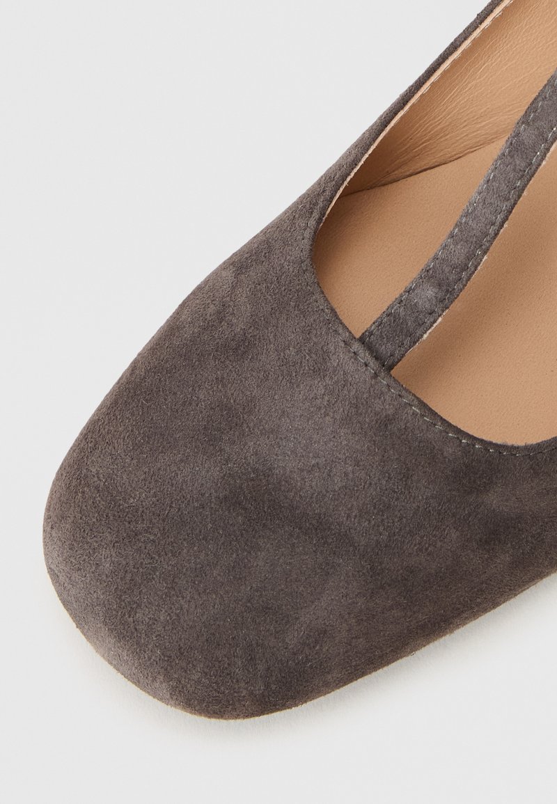 Szare zamszowe baleriny z zaokrąglonym palcem, elastycznym paskiem i gładką, lekką podeszwą. Wnętrze wyłożone beżowym materiałem syntetycznym.