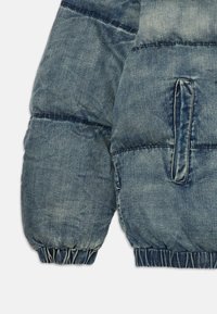 Leichte gepolsterte Jean-jacke in Hellblau mit elastischen Bündchen und einer Seitentasche. Verfügt über horizontale Nähte für Struktur und Textur.