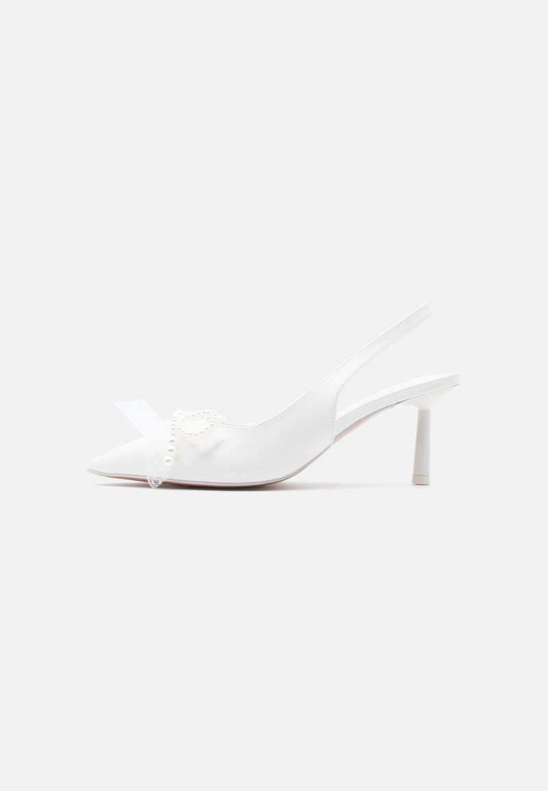 Escarpin slingback blanc pointu avec nœud décoratif et accents de perles sur l'avant, talon fin de hauteur moyenne, vue de côté sur fond blanc.