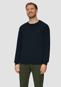 Marineblauer Strickpullover mit Rundhalsausschnitt, gerippten Bündchen und Saum, versehen mit einem dezenten Logo auf der Brust und einem weichen, strukturierten Finish.