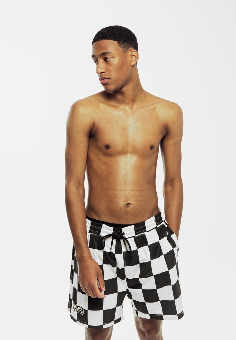 Costumi da bagno a scacchi bianco e nero con vita elasticizzata, cordoncino e un logo sul lato sinistro in basso.