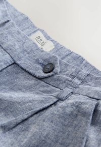 Pantaloni corti di lino blu con una finitura testurizzata, dotati di chiusura a bottone e un'etichetta che recita "next". Dettagliati con un design plissettato.