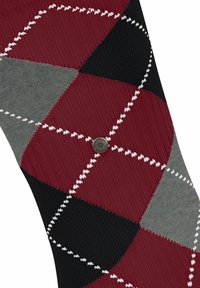 Chaussettes argyle colorées avec des motifs rouges, noirs, gris et blancs, en tricot texturé, agrémentées d'un petit bouton métallique logo.