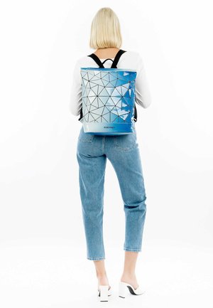Rucksack mit einem blauen geometrischen Muster, aus glänzendem Material gefertigt. Verfügt über verstellbare schwarze Träger, hat eine rechteckige Form und ein Markenlogo.