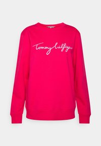 Felpa fucsia con colletto a girocollo, maniche lunghe e logo ricamato "Tommy Hilfiger" in bianco sulla parte anteriore. Tessuto morbido.