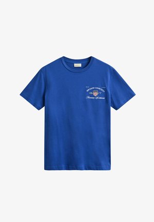Modré tričko s krátkým rukávem a kulatým výstřihem, s bílým textem/logo na levé straně hrudi s nápisem "GANT New Haven Connecticut American Sportswear."