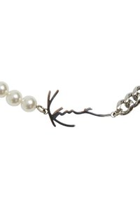 Pērļu kaklarota ar sudraba ķēdes posmiem un unikālu zaru formas aizdari. Pērles ir apaļas un spīdīgas, radot kontrastu ar tumšo metālu.