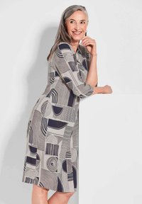 Grau- und marineblau gemustertes Kleid mit geometrischen Formen, Dreiviertelärmeln und lockerer Passform, aus leichtem Stoff.