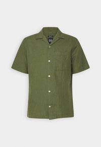 Camicia a maniche corte con bottoni in lino verde oliva, colletto a camicia, taschino sul petto e bottoni bianchi per la chiusura.