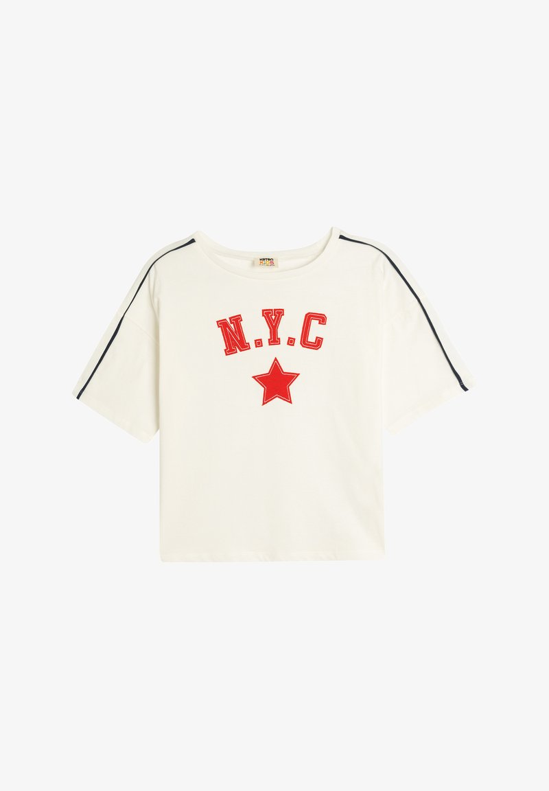 Hvid bomulds t-shirt med rød "N.Y.C." skrifttype og grafisk rød stjerne. Har sort kant langs skuldersømmene og korte ærmer.
