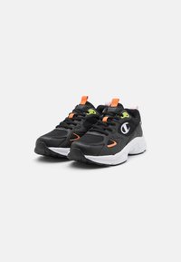 Scarpe da ginnastica nere con tomaia in mesh e sintetico, caratterizzate da accenti in verde neon e arancione, e una suola bianca. Doppie linguette per una facile indossatura.