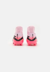 Le scarpe da calcio rosa e nere presentano una tomaia liscia in materiale sintetico, un tallone sagomato e spiccate accentuazioni nere, con una suola testurizzata per una presa ottimale.